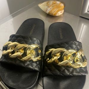 Black sandals with a gold buckle